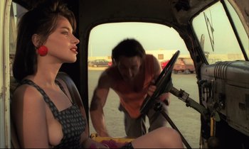 Movie still from “Betty Blue” (1986), directed by Jean-Jacques Beineix – A woman sitting in the back of a car next to a man; Medium shot, Over the shoulder angle