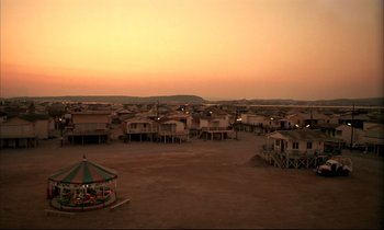 Movie still from “Betty Blue” (1986), directed by Jean-Jacques Beineix – An aerial view of a beach resort with a gazebo in the foreground; Extreme Wide shot, High angle