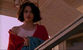Movie still from “Betty Blue” (1986), directed by Jean-Jacques Beineix – A woman holding a blue towel in front of a building; Close Up shot, Low angle