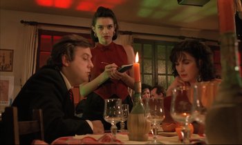 Movie still from “Betty Blue” (1986), directed by Jean-Jacques Beineix – A group of people sitting at a table with a candle; Medium shot, Low angle