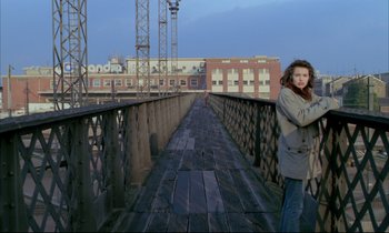 Movie still from “Betty Blue” (1986), directed by Jean-Jacques Beineix – A woman is standing on a wooden bridge; Wide shot, Low angle