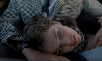 Movie still from “Betty Blue” (1986), directed by Jean-Jacques Beineix – A young woman laying on the ground wearing a suit and tie; Close Up shot, Overhead angle