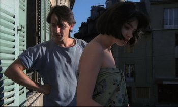 Movie still from “Betty Blue” (1986), directed by Jean-Jacques Beineix – A man and a woman standing next to each other on the street; Medium shot, Over the shoulder angle
