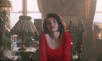 Movie still from “Betty Blue” (1986), directed by Jean-Jacques Beineix – A woman in a red shirt sitting in a room; Medium shot, Over the shoulder angle