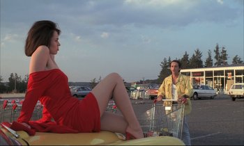 Movie still from “Betty Blue” (1986), directed by Jean-Jacques Beineix – A man and a woman sitting in front of a shopping cart; Medium shot, Low angle