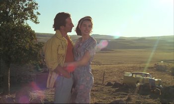 Movie still from “Betty Blue” (1986), directed by Jean-Jacques Beineix – A man and a woman standing next to each other in a field; Medium shot, Low angle