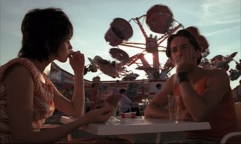 Movie still from “Betty Blue” (1986), directed by Jean-Jacques Beineix – Two people sitting at a table eating food; Medium shot, Low angle