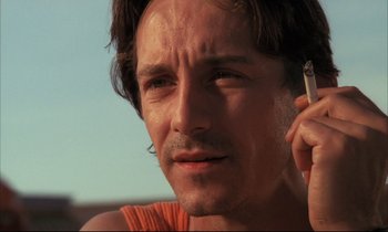 Movie still from “Betty Blue” (1986), directed by Jean-Jacques Beineix – A person talking on a cell phone; Close Up shot, Low angle