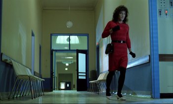 Movie still from “Betty Blue” (1986), directed by Jean-Jacques Beineix – A woman in a red dress walking down a hall way; Wide shot, Low angle
