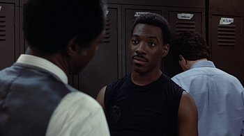Movie still from “Beverly Hills Cop” (1984), directed by Martin Brest – A man in black shirt talking to another man in black shirt; Close Up shot, Over the shoulder angle