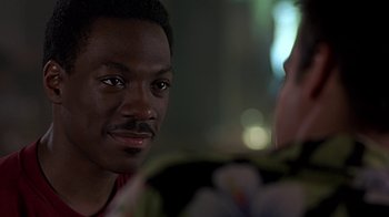 Movie still from “Beverly Hills Cop” (1984), directed by Martin Brest – A person talking to another person; Close Up shot, Over the shoulder angle