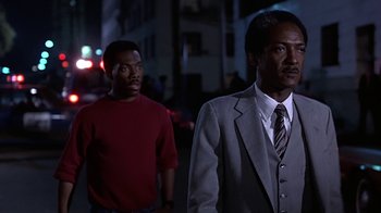 Movie still from “Beverly Hills Cop” (1984), directed by Martin Brest – Two men are walking down the street at night; Medium shot, Low angle