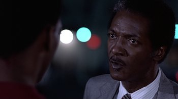 Movie still from “Beverly Hills Cop” (1984), directed by Martin Brest – A man in a suit and tie talking to another man in a suit and tie; Close Up shot, Over the shoulder angle