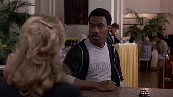 Movie still from “Beverly Hills Cop” (1984), directed by Martin Brest – A man sitting at a table in front of a woman; Close Up shot, Over the shoulder angle