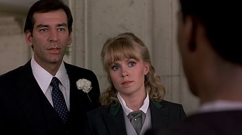 Movie still from “Beverly Hills Cop” (1984), directed by Martin Brest – A man and a woman standing next to each other; Close Up shot, Over the shoulder angle