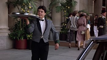 Movie still from “Beverly Hills Cop” (1984), directed by Martin Brest – A man in a tuxedo carrying a tray of food; Medium shot, Low angle