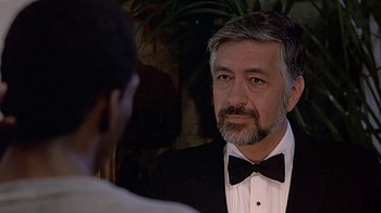 Movie still from “Beverly Hills Cop” (1984), directed by Martin Brest – A person wearing a suit and a bow tie; Close Up shot, Over the shoulder angle