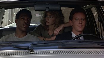 Movie still from “Beverly Hills Cop” (1984), directed by Martin Brest – A group of people sitting in the back of a car; Medium shot, Over the shoulder angle