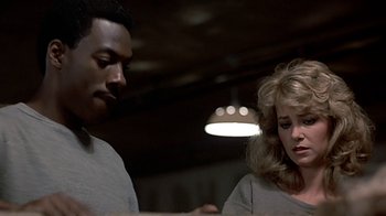 Movie still from “Beverly Hills Cop” (1984), directed by Martin Brest – A man and a woman are looking at each other; Close Up shot, Low angle