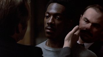 Movie still from “Beverly Hills Cop” (1984), directed by Martin Brest – A black man is looking at a white man; Close Up shot, Over the shoulder angle