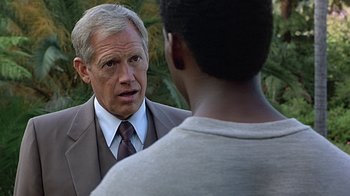 Movie still from “Beverly Hills Cop” (1984), directed by Martin Brest – A man wearing a suit and tie talking to another man wearing a shirt and tie; Close Up shot, Over the shoulder angle