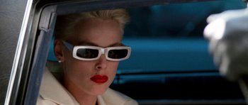 Movie still from “Beverly Hills Cop II” (1987), directed by Tony Scott – A woman with white sunglasses and red lipstick in a car; Close Up shot, Over the shoulder angle