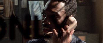 Movie still from “Beverly Hills Cop II” (1987), directed by Tony Scott – A person talking on a cell phone; Close Up shot, High angle