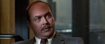 Movie still from “Beverly Hills Cop II” (1987), directed by Tony Scott – A person wearing a suit and tie; Close Up shot, Low angle