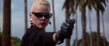 Movie still from “Beverly Hills Cop II” (1987), directed by Tony Scott – A woman with blonde hair wearing sunglasses and holding a gun; Close Up shot, Low angle