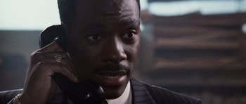 Movie still from “Beverly Hills Cop II” (1987), directed by Tony Scott – A person talking on a phone; Close Up shot, High angle