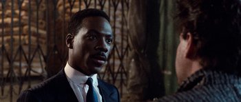 Movie still from “Beverly Hills Cop II” (1987), directed by Tony Scott – A man in a suit and a tie; Close Up shot, Over the shoulder angle