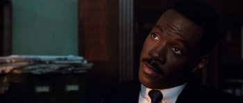 Movie still from “Beverly Hills Cop II” (1987), directed by Tony Scott – A man in a suit and a tie; Close Up shot, Low angle