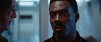 Movie still from “Beverly Hills Cop II” (1987), directed by Tony Scott – A person wearing a black shirt; Close Up shot, Over the shoulder angle