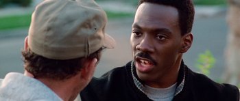 Movie still from “Beverly Hills Cop II” (1987), directed by Tony Scott – A man talking to another man in a hat; Close Up shot, Over the shoulder angle