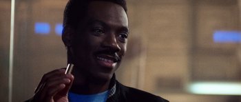 Movie still from “Beverly Hills Cop II” (1987), directed by Tony Scott – A person holding a pencil in his hand; Close Up shot, Over the shoulder angle