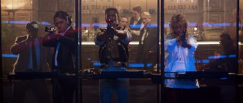 Movie still from “Beverly Hills Cop II” (1987), directed by Tony Scott – A man holding a cell phone while standing in front of a bar; Wide shot, Over the shoulder angle