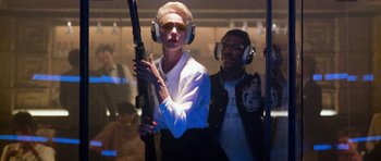 Movie still from “Beverly Hills Cop II” (1987), directed by Tony Scott – A man and a woman wearing ear muffs and holding a gun; Medium shot, Low angle