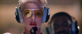 Movie still from “Beverly Hills Cop II” (1987), directed by Tony Scott – A woman with blonde hair wearing sunglasses and headphones; Close Up shot, Low angle
