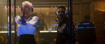 Movie still from “Beverly Hills Cop II” (1987), directed by Tony Scott – A man with headphones is standing in front of a mirror; Medium shot, Over the shoulder angle