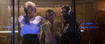 Movie still from “Beverly Hills Cop II” (1987), directed by Tony Scott – A group of people wearing headphones and standing next to each other; Medium shot, Low angle