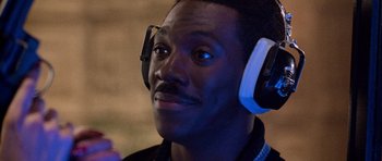 Movie still from “Beverly Hills Cop II” (1987), directed by Tony Scott – A person wearing ear muffs; Close Up shot, High angle