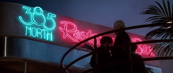 Movie still from “Beverly Hills Cop II” (1987), directed by Tony Scott – Two people walking up a set of stairs in front of a restaurant sign; Wide shot, Low angle