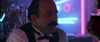 Movie still from “Beverly Hills Cop II” (1987), directed by Tony Scott – A person with a mustache wearing a suit; Close Up shot, Low angle