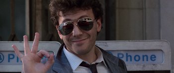 Movie still from “Beverly Hills Cop II” (1987), directed by Tony Scott – A person wearing a suit and sunglasses; Close Up shot, Low angle