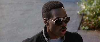 Movie still from “Beverly Hills Cop II” (1987), directed by Tony Scott – A person wearing sunglasses and a jacket; Close Up shot, Low angle