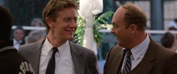 Movie still from “Beverly Hills Cop II” (1987), directed by Tony Scott – Two men in business suits talking to each other; Close Up shot, Over the shoulder angle