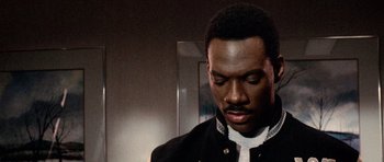 Movie still from “Beverly Hills Cop II” (1987), directed by Tony Scott – A man in a black jacket is looking down; Close Up shot, High angle