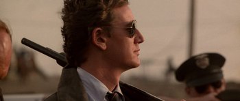 Movie still from “Beverly Hills Cop II” (1987), directed by Tony Scott – A person wearing a suit and sunglasses; Close Up shot, Low angle