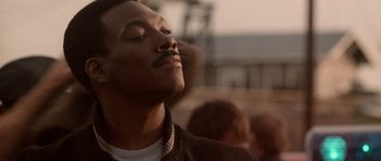 Movie still from “Beverly Hills Cop II” (1987), directed by Tony Scott – A person with their eyes closed; Close Up shot, Low angle