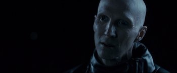 A man with a bald head wearing a leather jacket
